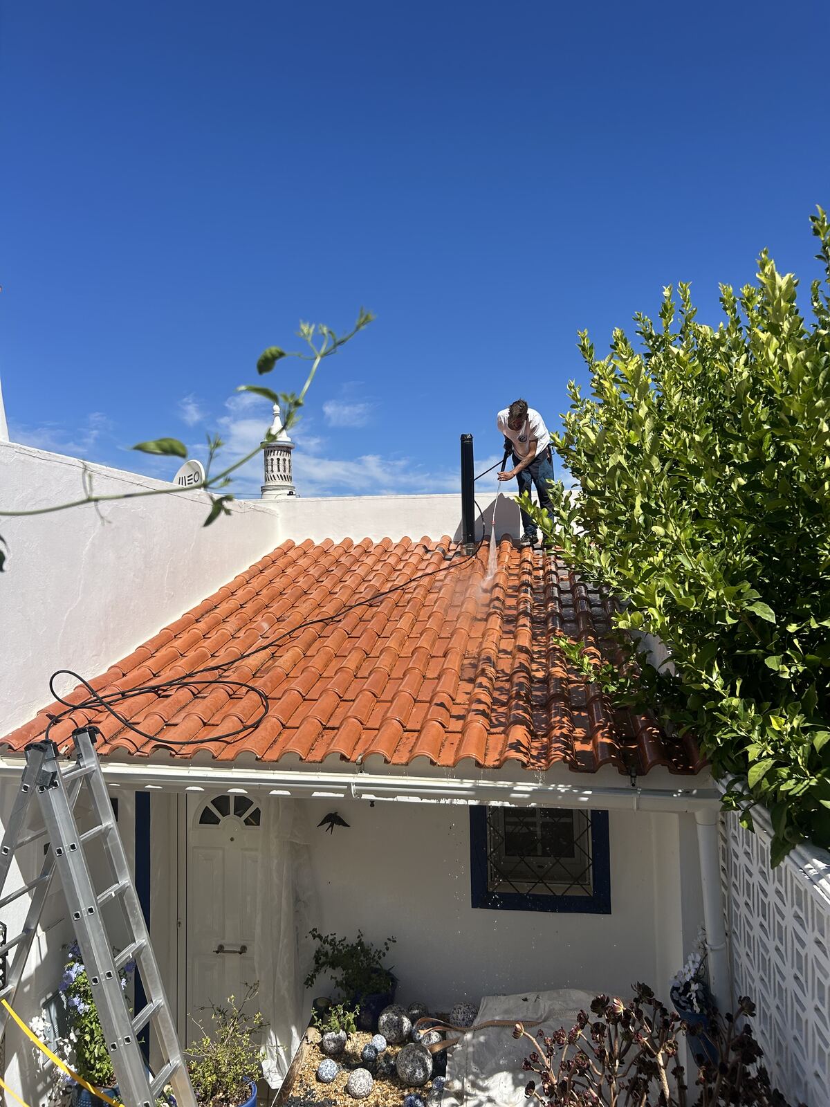 Whitehouse Services soft washing terracotta roof tiles on a townhouse in Tavira, Algarve
