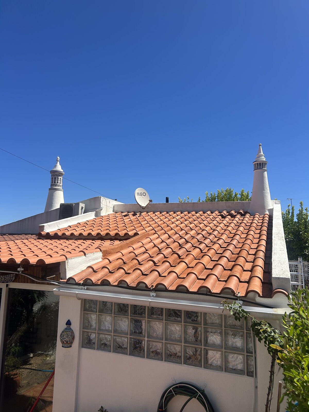 Terracotta roof tiles restored after professional soft washing in the Algarve