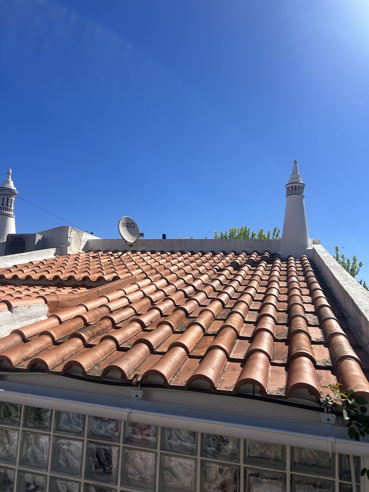 Terracotta roof tiles covered in moss before soft washing in the Algarve